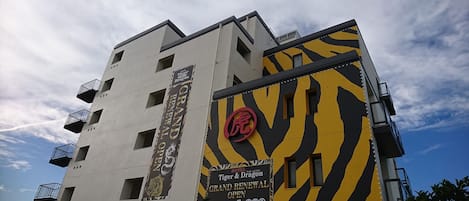 A hotel building with a tiger and dragon theme, featuring balconies and multiple windows.