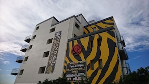 A hotel building with a tiger and dragon theme, featuring balconies and multiple windows.