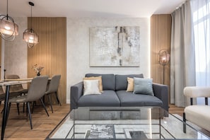 Un salon moderne avec un canapé, une table basse et des luminaires suspendus.