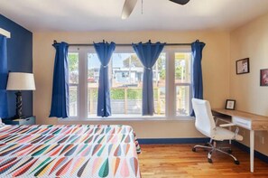 A bedroom with a bed, a desk, a chair, and a window with curtains. - Lemonade & Sunshine Near Downtown Oceanside (Oceanside)