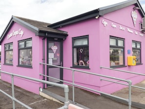 A pink building with a sign that reads 'Charlie Crepes Cafe.' - Twyni Bach (Burry Port)