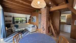 A cozy cabin interior with a living area, a dining table, and a kitchen. - Casa Ines with Lake Maggiore View (Villaggio Olandese)