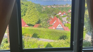 A window with a view of a green landscape and red-roofed buildings. - Casa Ines with Lake Maggiore View (Villaggio Olandese)
