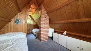 A cozy attic bedroom with a sloped ceiling, a bed, a desk, and a wardrobe. - Casa Ines with Lake Maggiore View (Villaggio Olandese)