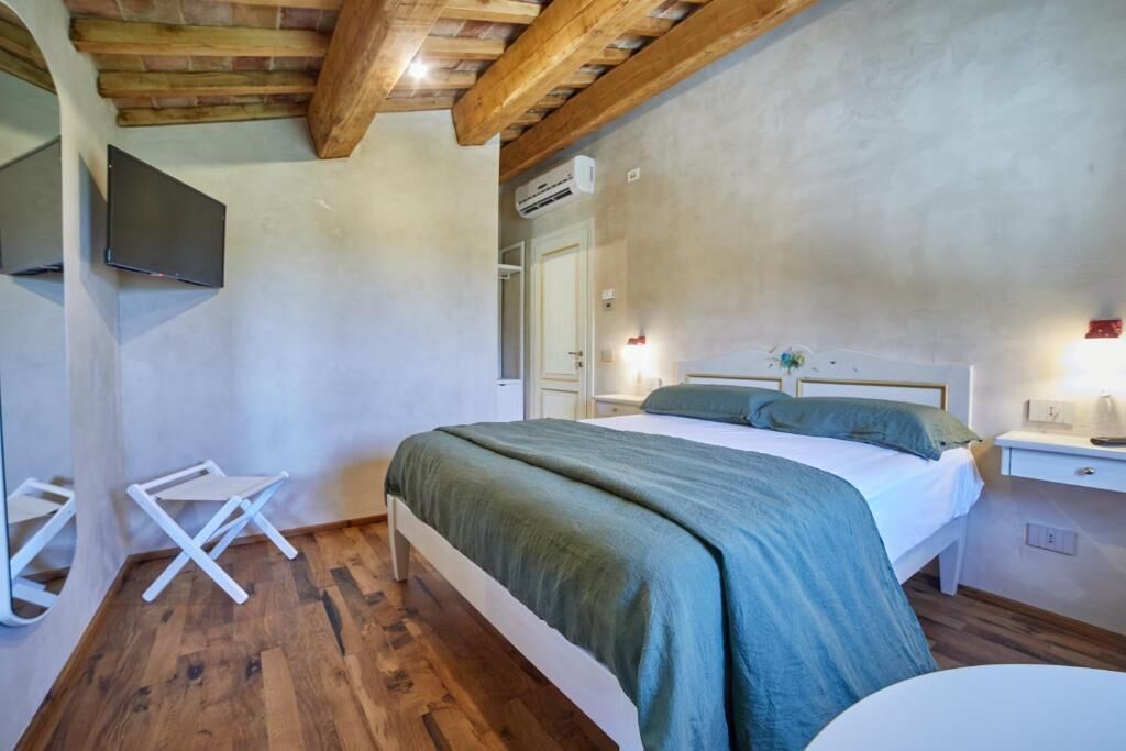 Une chambre à coucher avec un lit, des tables de chevet, un téléviseur et un plafond en bois.