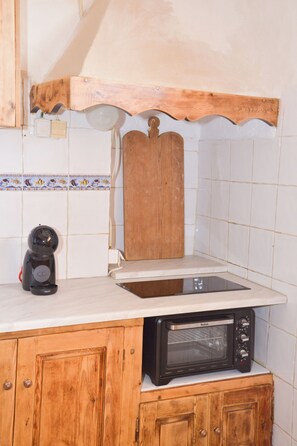 Eine Küche mit Mikrowelle, Kaffeemaschine und Holzschränken.