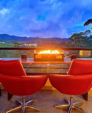 A terrace with a fire feature, two red chairs, and a view of mountains. - Listing With Bookings, Messages abc (Pattaya)