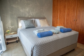 Un dormitorio con cama, mesita de noche, armario de madera y pared con textura.