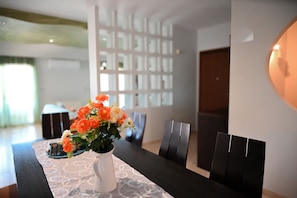 A dining table with a vase of flowers, black chairs, and a patterned tablecloth. - ✨ Erato Superior Suite: Your Modern Oasis 🏛️ (Κρεμαστή)