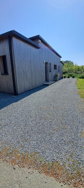 Un bâtiment avec une allée en gravier et un petit jardin.