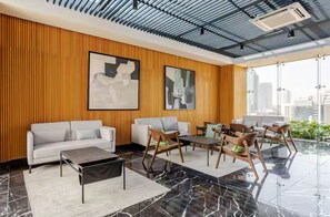 A modern interior with a sofa, chairs, a coffee table, and artwork on the wall. - Design Loft - ICON Roma - Rooftop Pool + Bar - Heart of CDMX (Ciudad de México)