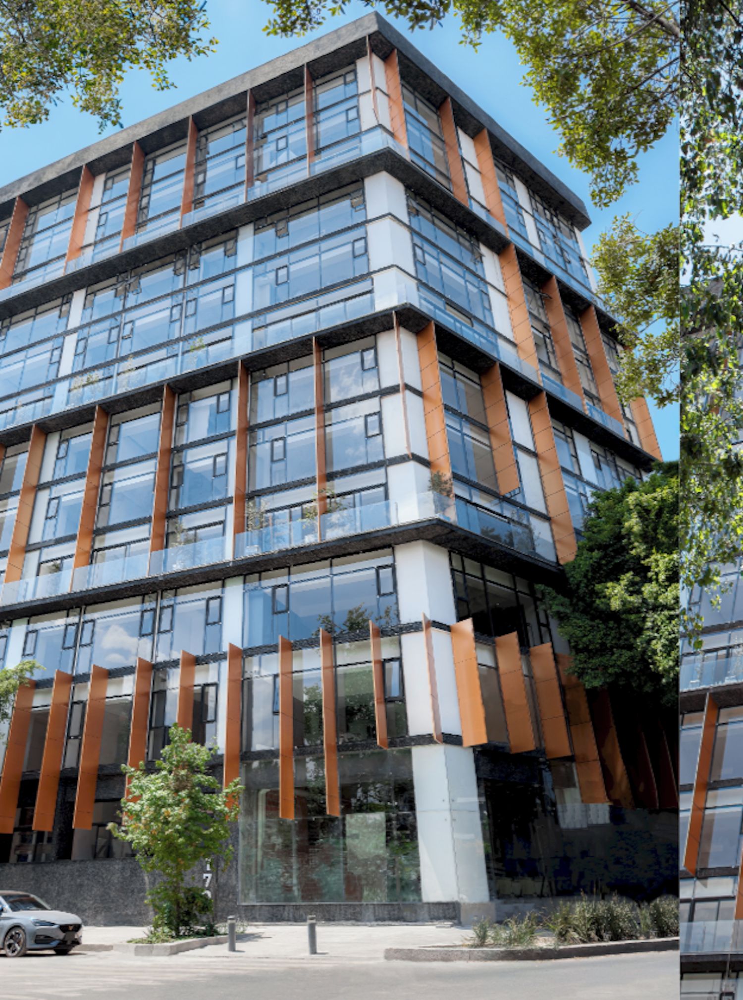 Un edificio moderno de varios pisos con grandes ventanales y fachada de vidrio y metal.