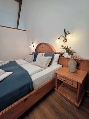 Ein Schlafzimmer mit einem hölzernen Bett, Nachttischen und Wandleuchten.