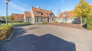 Ett bostadsområde med en asfalterad uppfart, en gatlykta och hus med fasader av tegel och tak belagda med takpannor.
