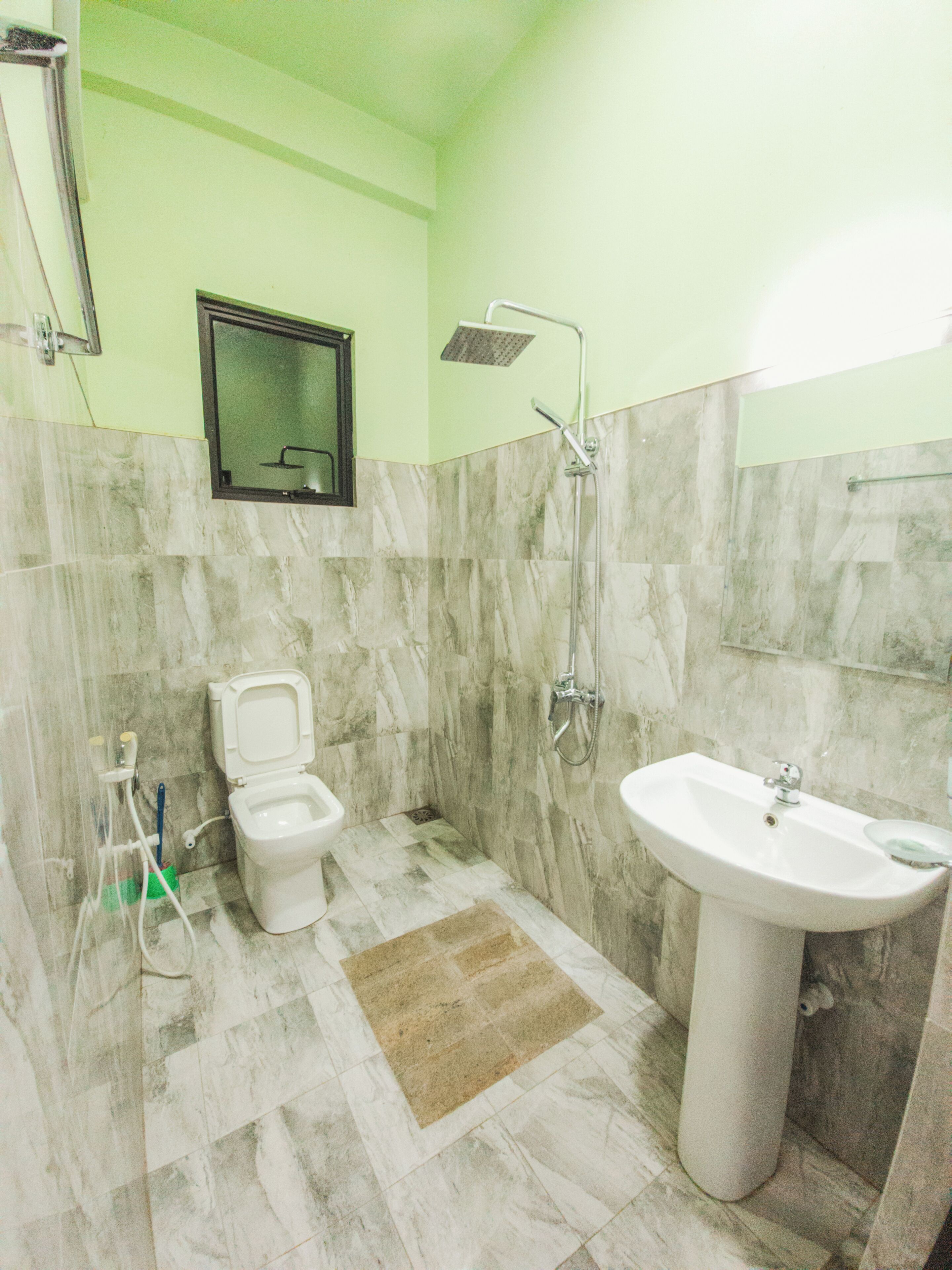 A bathroom with a toilet, bidet, shower, and sink.