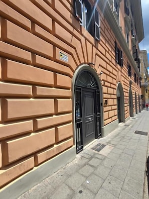 A building with a brick facade, a black arched entrance, and a clear sky. - THE ETRURIAN RAPSODY (Roma)