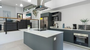 Una cucina moderna con isola centrale, elettrodomestici integrati e vista sull'esterno.