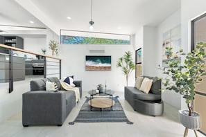 A modern living room with two sofas, a coffee table, and a large window. - Brand New 3 Bedroom Villa, Walking Distance to Tamarindo and Langosta (Playa Langosta)