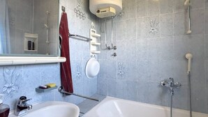 A bathroom with a bathtub, a sink, a mirror, a towel rack, and a shower. - 2 Bedroom Apartment Bor in Poljana (Preko)