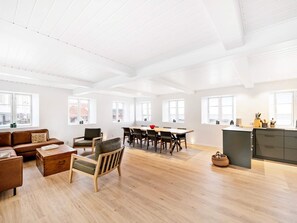 Un amplio salón con una mesa de comedor, sofás y una zona de cocina.
