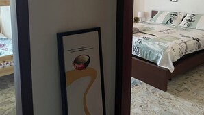 A bedroom with a bed, a nightstand, a framed picture, and a tiled floor. - CasaElia | Path of the Gods & Amalfi Coast (Pianillo)
