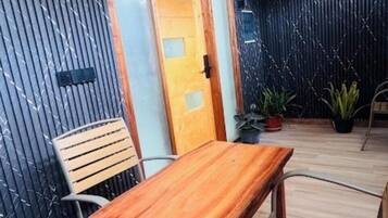 A room with a wooden table and chairs, a ceiling fan, and a door with frosted glass panels.