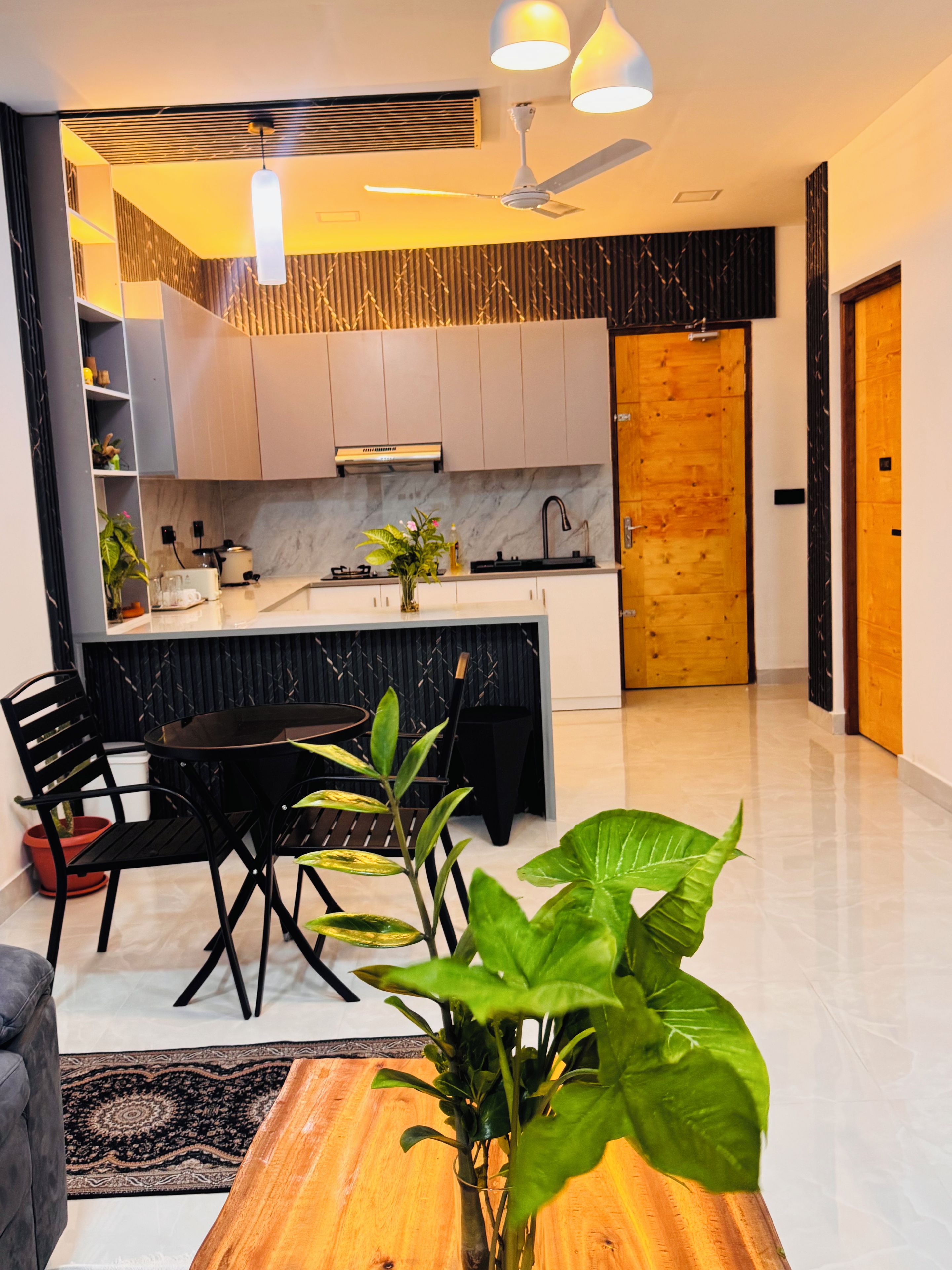 Uma cozinha moderna com uma ilha central, cadeiras pretas e uma mesa de jantar.