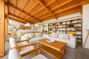 A spacious living area with a wooden ceiling, a sofa set, a coffee table, and a bookshelf. - Gorgeous 3-bedroom house in São Martinho do Porto near the beach (São Martinho do Porto)