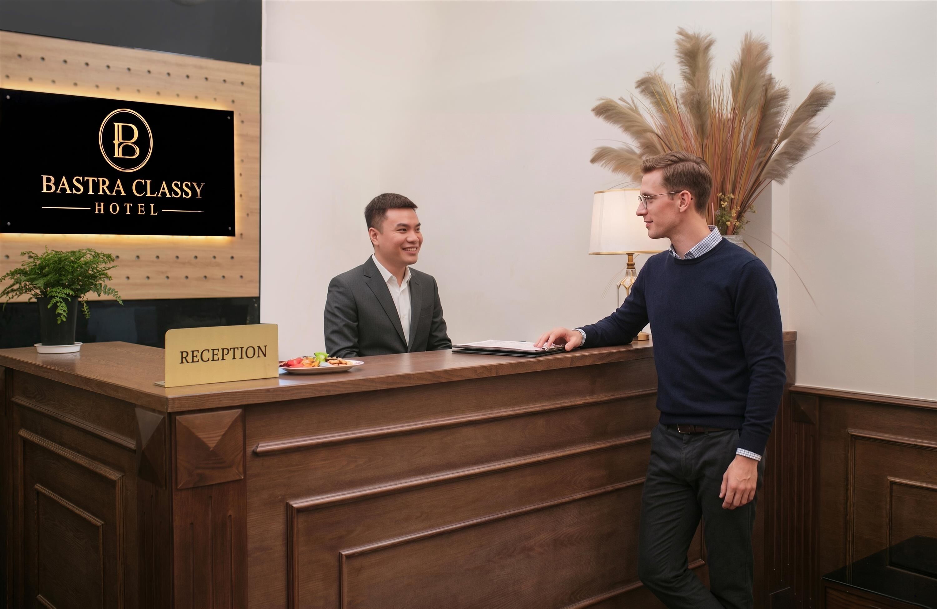 A reception desk at the BASTRA CLASSY HOTEL with a sign indicating the reception area.