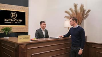 Mostrador de recepción en el HOTEL BASTRA CLASSY, con un cartel que indica la zona de recepción.