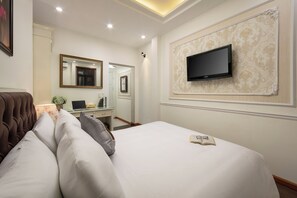 A hotel room with a bed, a TV mounted on the wall, a desk with a computer, and a mirror. - Bastra Classy Hotel (Hoan Kiem Ward)