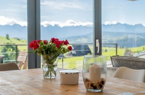 A table with a vase of red flowers, a candle, and a glass container with nuts. - Home With a Bathtub Overlooking the Mountains (Bukowina Tatrzanska)