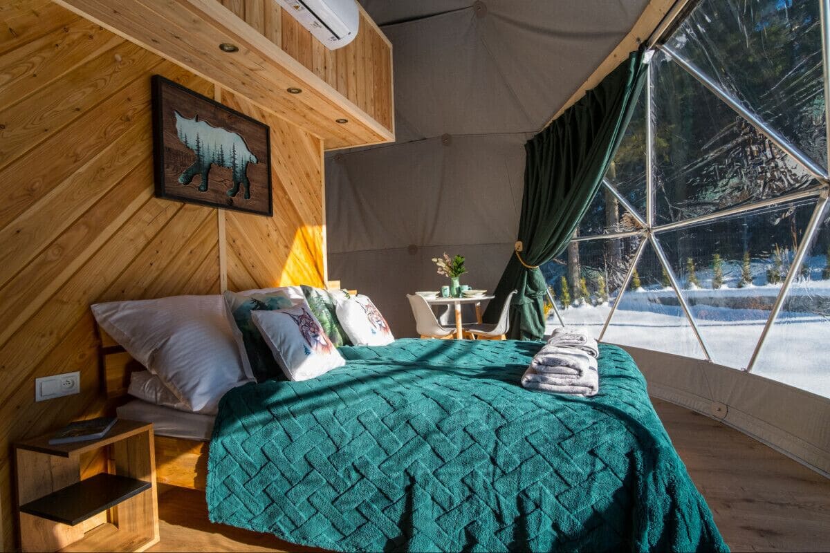 Una habitación acogedora con cama, almohadas, una mesa y una silla.