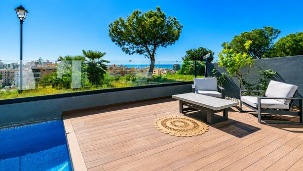 Uma área de piscina no terraço com vista para a cidade, um poste de luz e uma árvore.