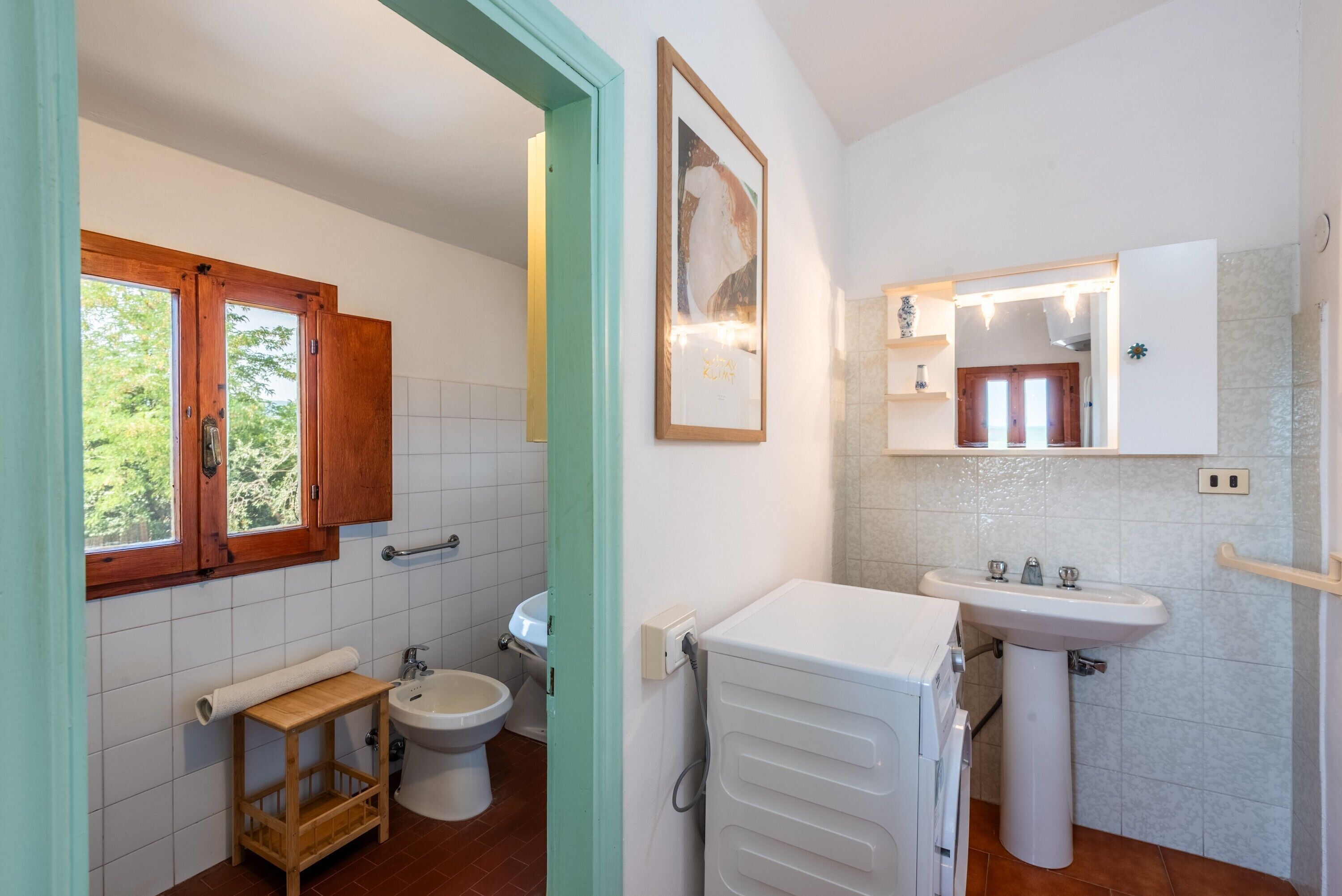 Une salle de bain comprenant des toilettes, un bidet, un lavabo et un porte-serviettes.