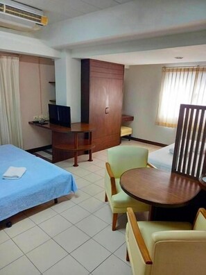 A hotel room with a bed, a desk, a chair, a small table, and a wardrobe. - Bella B Plus Hotel (Bangkok)