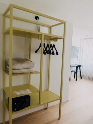 A yellow metal wardrobe with shelves, a hanging rack, and a microwave drawer.