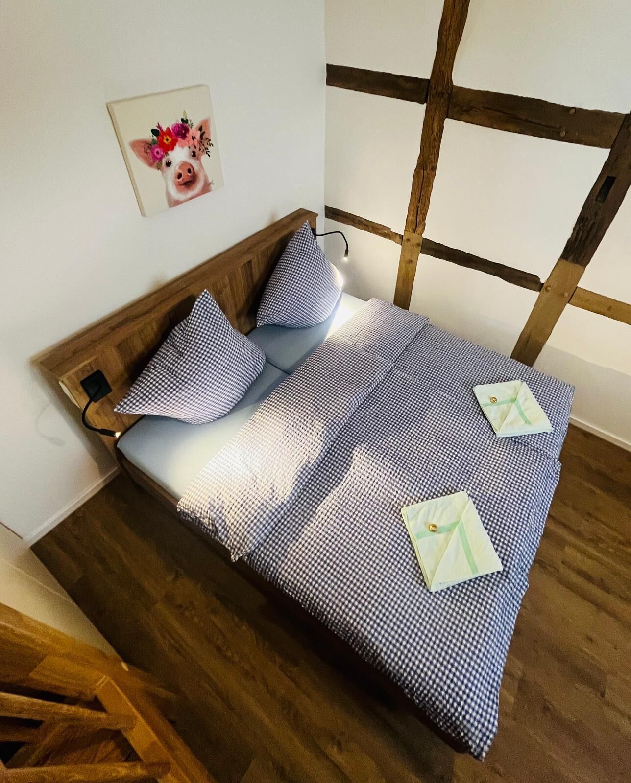 Un lit avec une couvre-lit à carreaux, des oreillers et une tête de lit en bois.