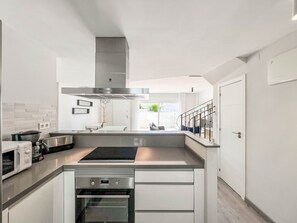 Eine moderne Küche mit Einbauofen, Mikrowelle und Dunstabzugshaube aus Edelstahl.