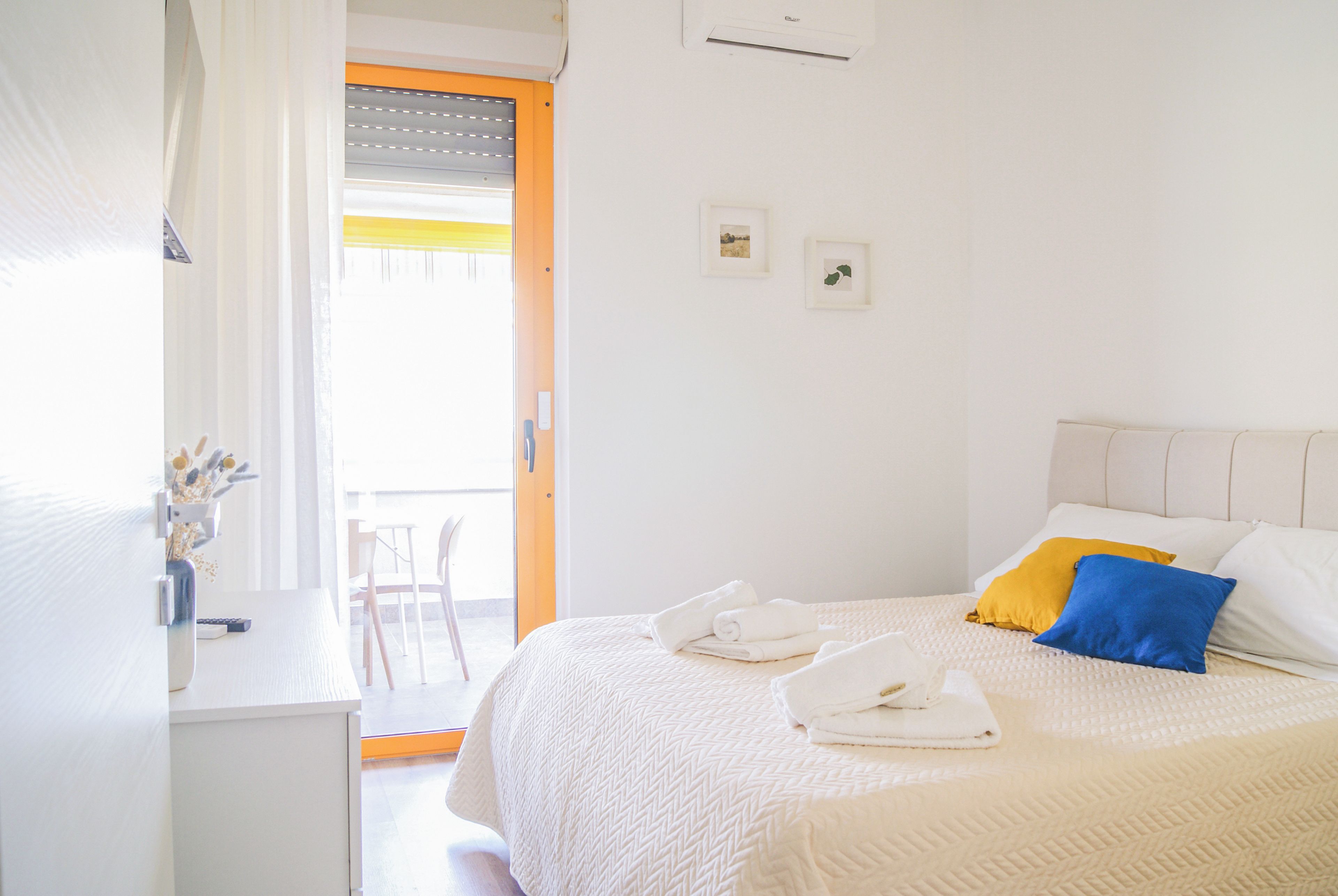 A bedroom with a bed, pillows, a desk, and a chair.