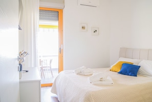 A bedroom with a bed, pillows, a desk, and a chair. - Casa Eos (Torre A Mare)