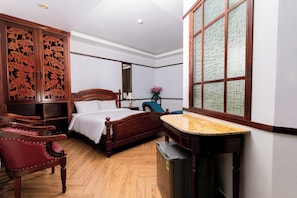 Ein Schlafzimmer mit einem hölzernen Bett, einem Schreibtisch, einem Stuhl, einem Kleiderschrank und einem Fenster mit Blick.