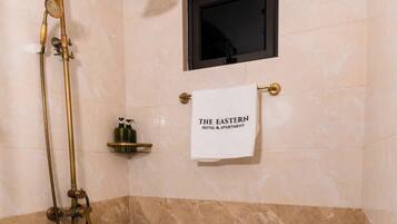 Familie suite | Badkamer | Een douche, een haardroger, handdoeken, zeep