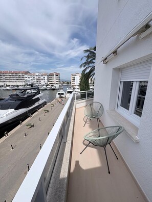 Ein Balkon mit Blick auf eine Marina, einschließlich Boote und Gebäuden im Hintergrund.
