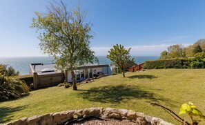 A coastal property with a stone wall, a wooden deck, and a view of the sea. - Kittiwake (Ventnor)