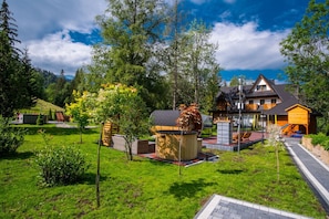 Una casa moderna con una amplia terraza, un jacuzzi y una zona de juegos.