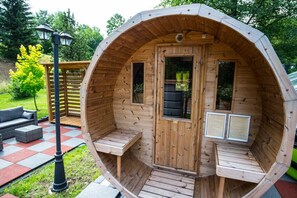 A wooden cabin with a curved roof, a door, and two windows.