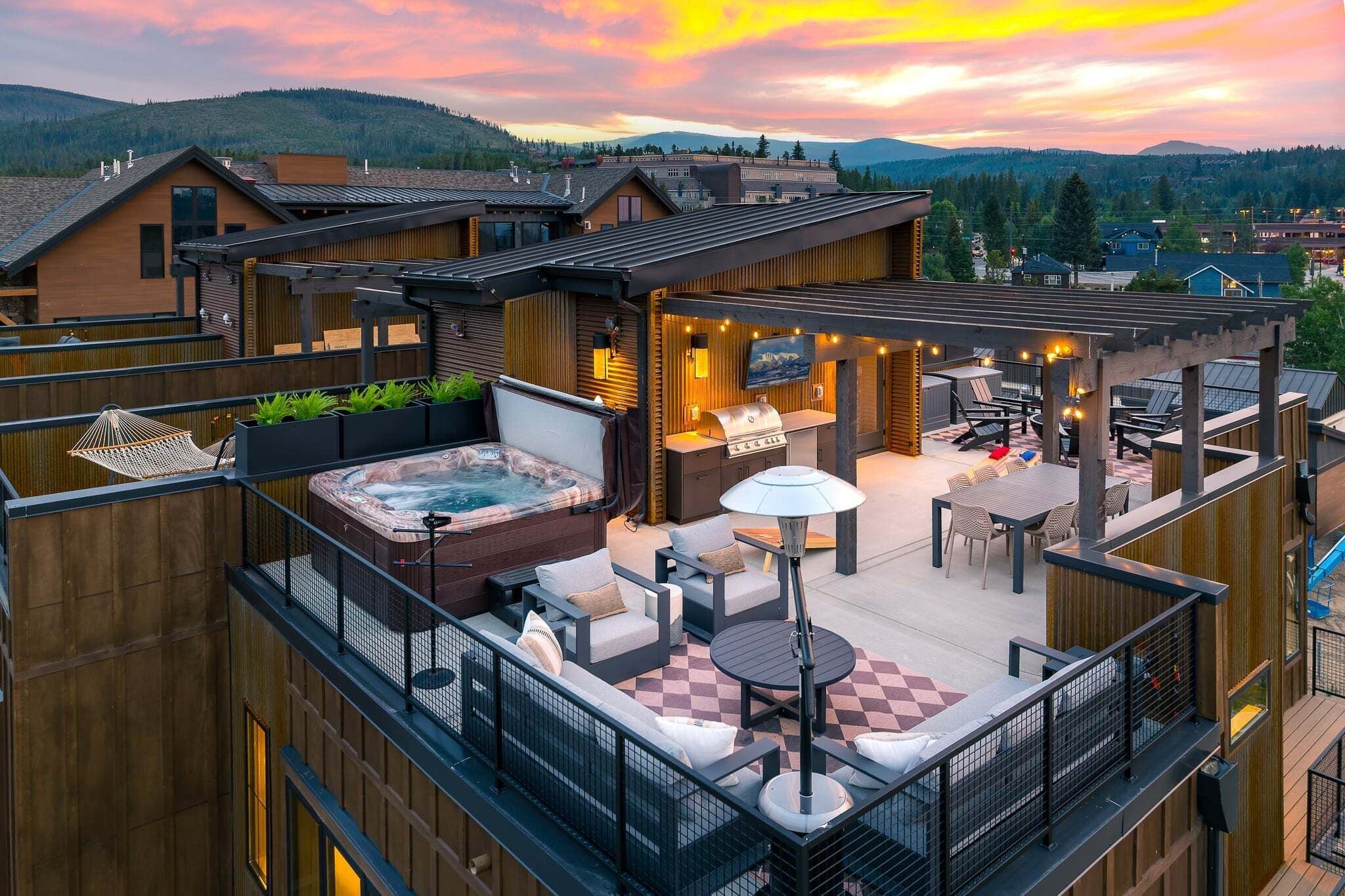 Eine Dachterrasse mit Whirlpool, Sitzgelegenheiten im Freien und Blick auf die Umgebung.