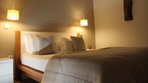 A hotel room with a bed, bedside tables, and two pendant lights. - Quinta da Corujeira (Vila Real)