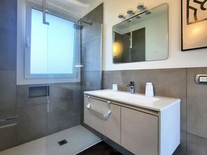 A modern bathroom with a glass shower enclosure, a large mirror, and a white sink. - Casa  Loco (Piemonte)